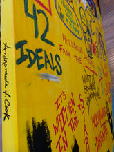 Load image into Gallery viewer, Detail of Hollywood Dreams painting by Andromeda Cook showing bold yellow canvas, layered text, expressive brushwork, Basquiat-inspired markings, 528hz frequency, Self Portrait as a Legend, M31 Andromeda galaxy, and divine feminine energy
